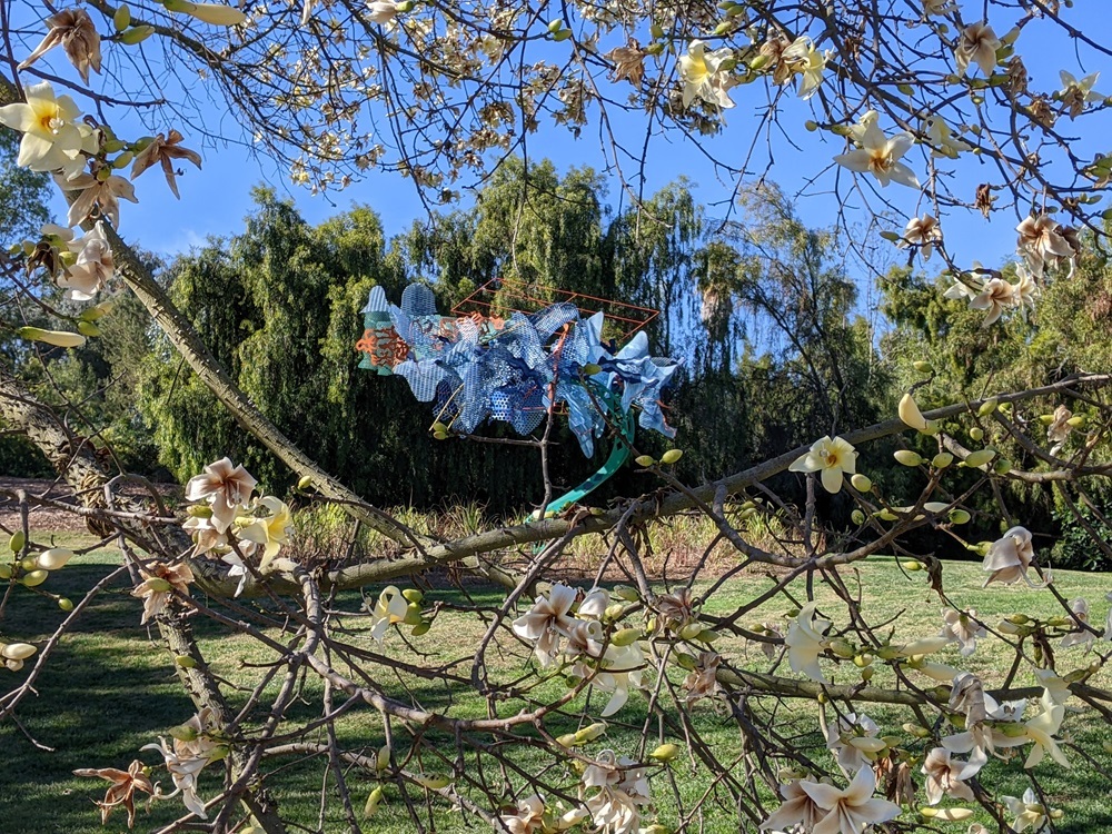 Trace, by Nancy Graves - a bronze and polychromed patina steel sculpture, framed by a flowering tree